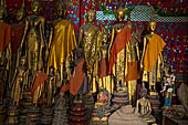 Wat Xieng Thong temple in Luang Prabang, Laos. standing Buddha statues in the  calling for rain  mudra with both arms down at sides and palms against thighs. Royal Funerary carriage hall. 